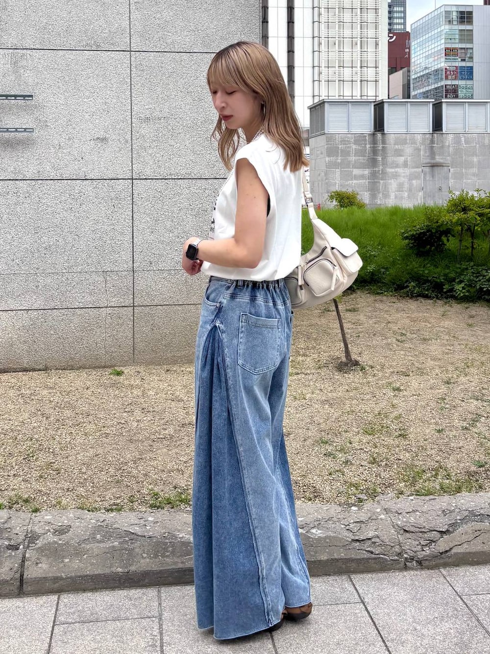 ブルー系のデニムパンツ、ホワイト系のショルダーバッグ、ホワイト系のTシャツ/カットソーを着用したレディースの夏コーディネートの3枚目の写真