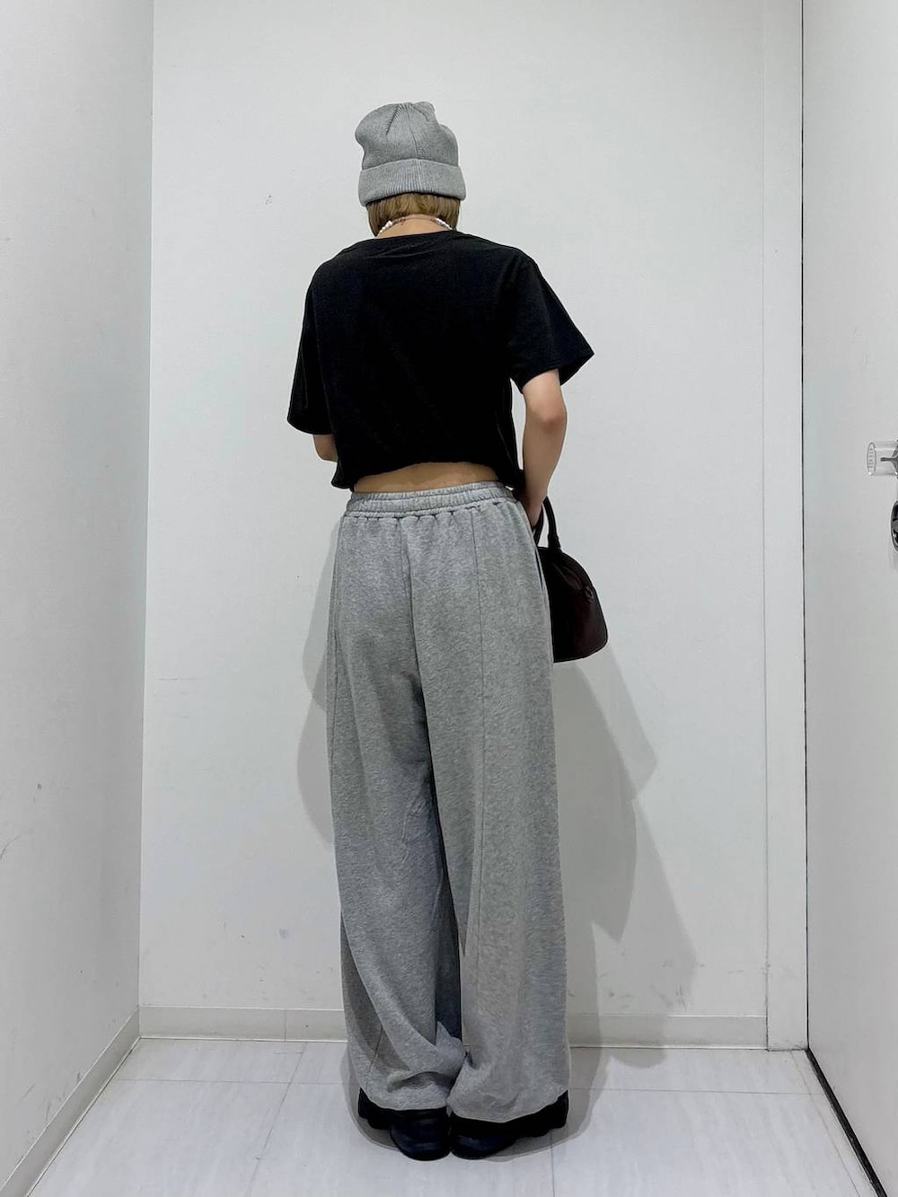 ブラウン系のショルダーバッグ、グレー系のスウェットパンツ、グレー系のTシャツ/カットソーを着用したレディースの夏コーディネートの4枚目の写真