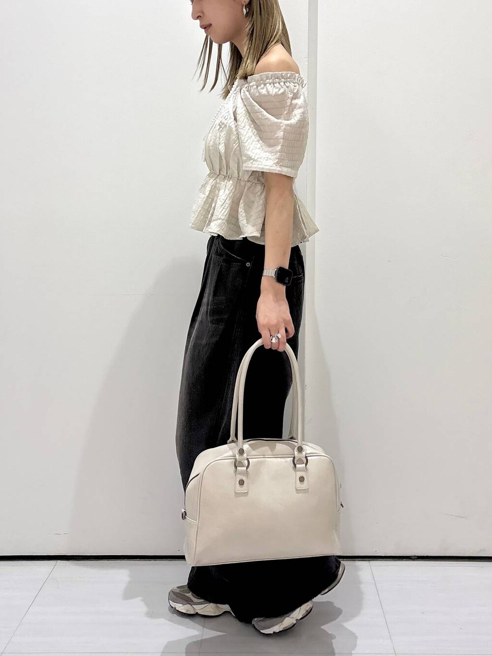 ブラック系のデニムパンツ、ホワイト系のボストンバッグ、ホワイト系のネックレスを着用したレディースの夏コーディネートの3枚目の写真