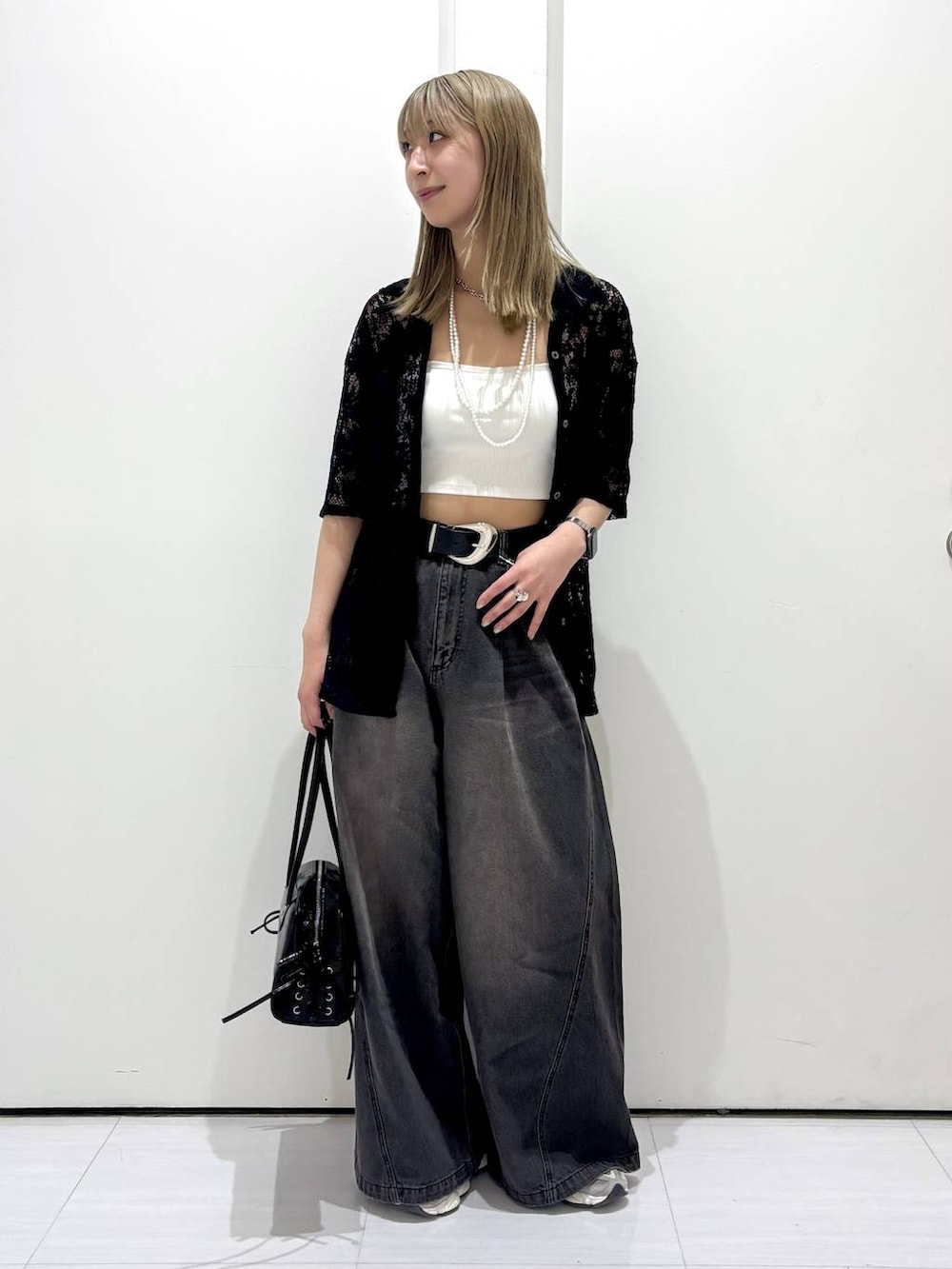 ブラック系のデニムパンツ、ブラック系のショルダーバッグ、ブラック系のシャツ/ブラウスを着用したレディースの春コーディネートの6枚目の写真