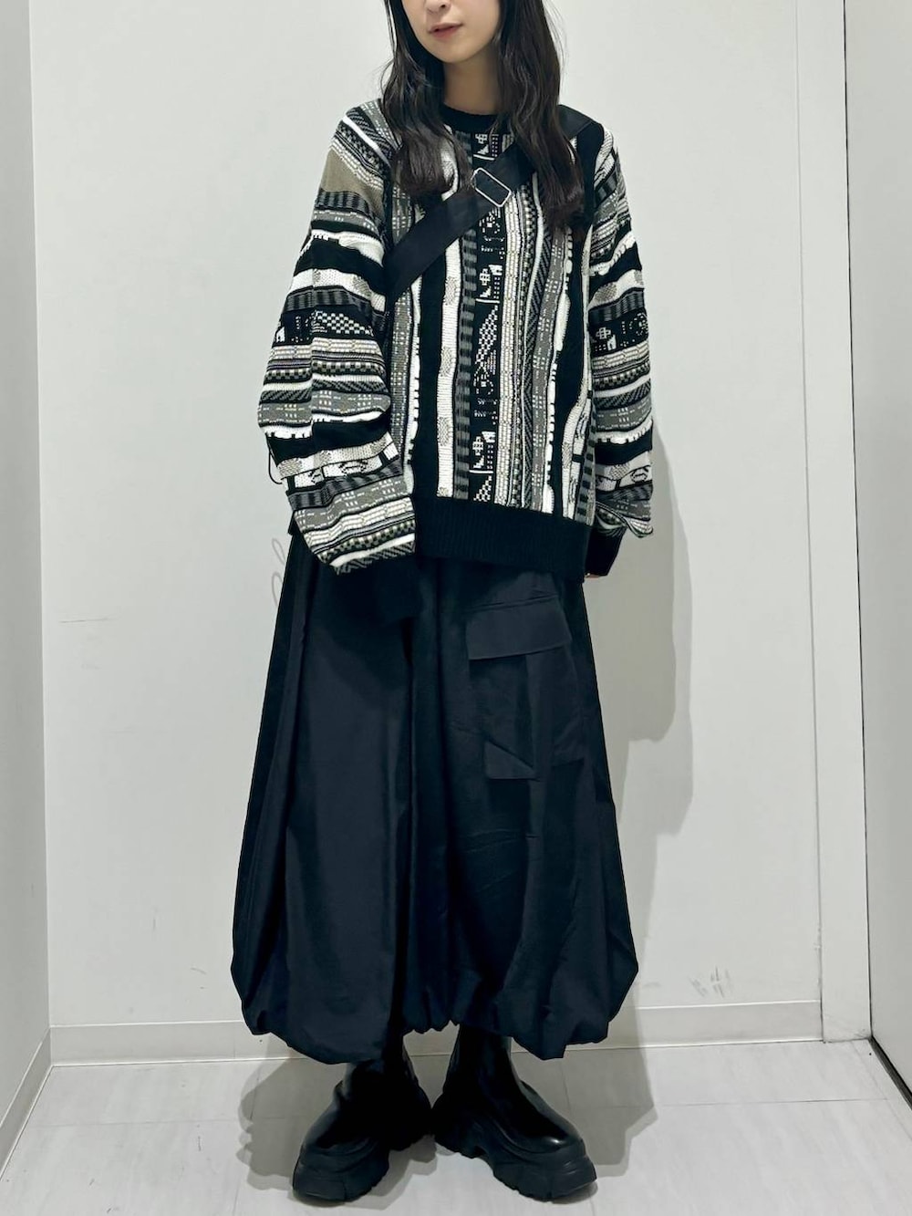 ブラック系のブーツ、ブラック系のショルダーバッグ、ブラック系のニット/セーターを着用したレディースの秋コーディネートの2枚目の写真