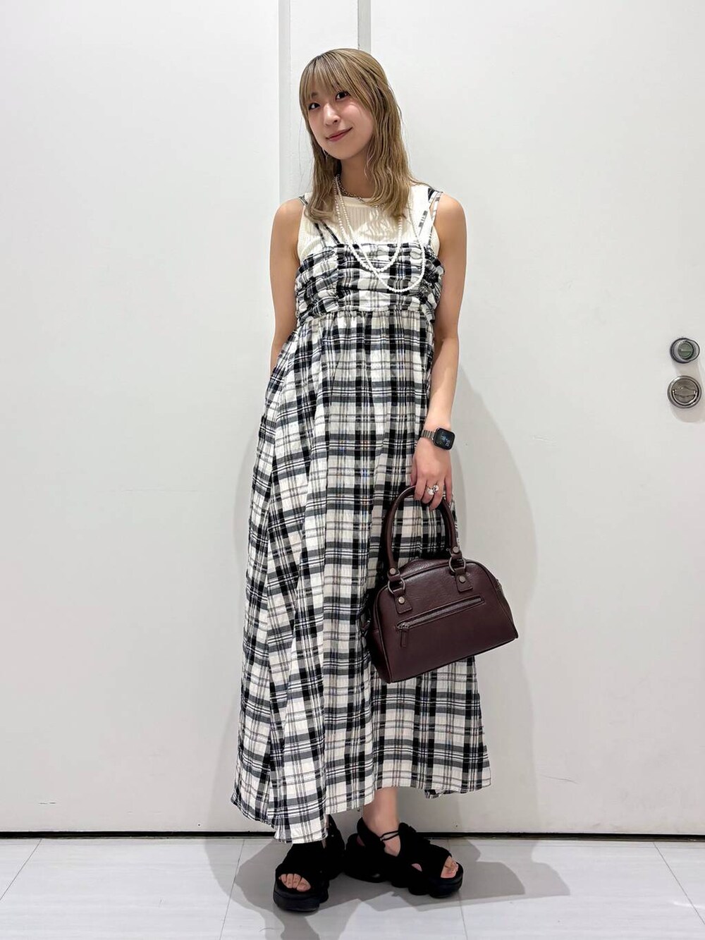 ホワイト系のタンクトップ、ブラウン系のショルダーバッグ、ホワイト系のワンピースを着用したレディースの夏コーディネートの6枚目の写真