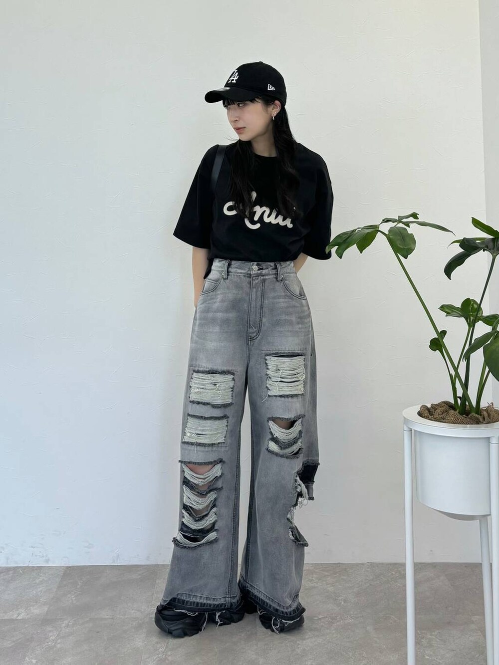 ブラック系のデニムパンツ、ブラック系のスニーカー、ブラック系のTシャツ/カットソーを着用したレディースの春コーディネートの6枚目の写真