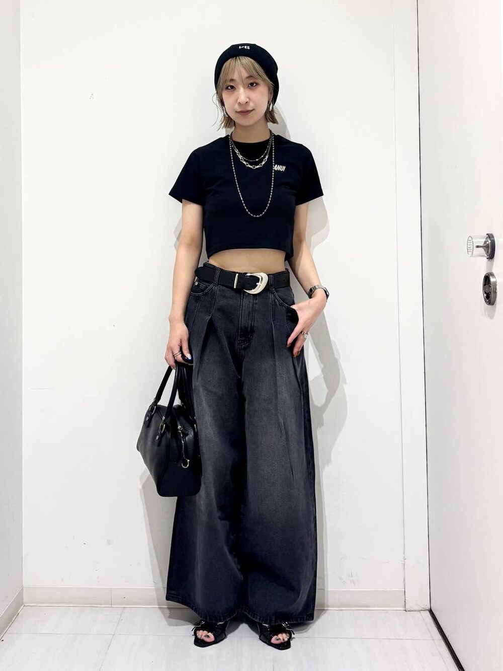 ブラック系のデニムパンツ、ブラック系のサンダル、ブラック系のTシャツ/カットソーを着用したレディースの夏コーディネートの5枚目の写真