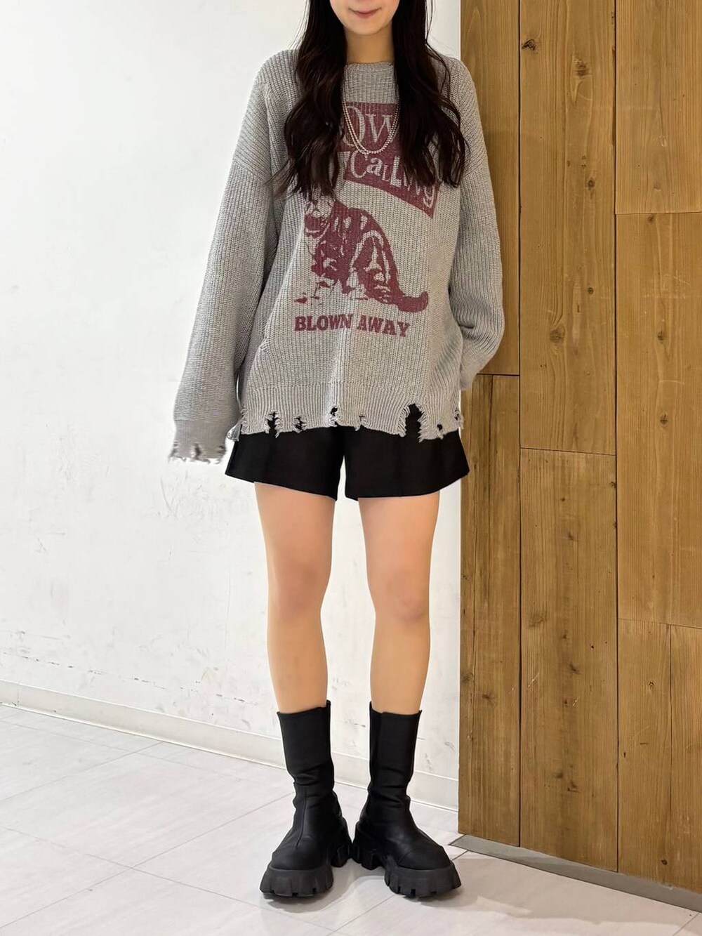 ブラック系のその他パンツ、ホワイト系のTシャツ/カットソー、グレー系のニット/セーターを着用したレディースの冬コーディネートの2枚目の写真