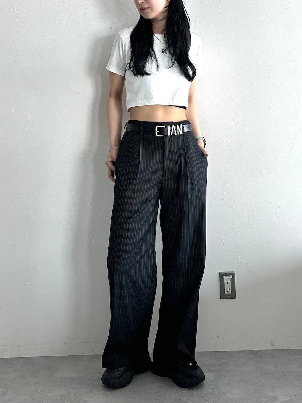 ホワイト系のTシャツ/カットソー、ブラック系のスラックス、ブラック系のベルトを着用したレディースの春コーディネートの2枚目の写真