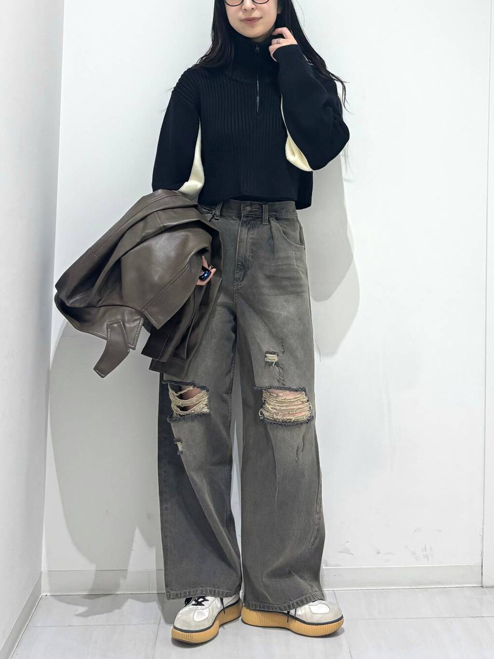 ブラウン系のブルゾン、ブラック系のデニムパンツ、ブラック系のニット/セーターを着用したレディースの秋コーディネートの5枚目の写真