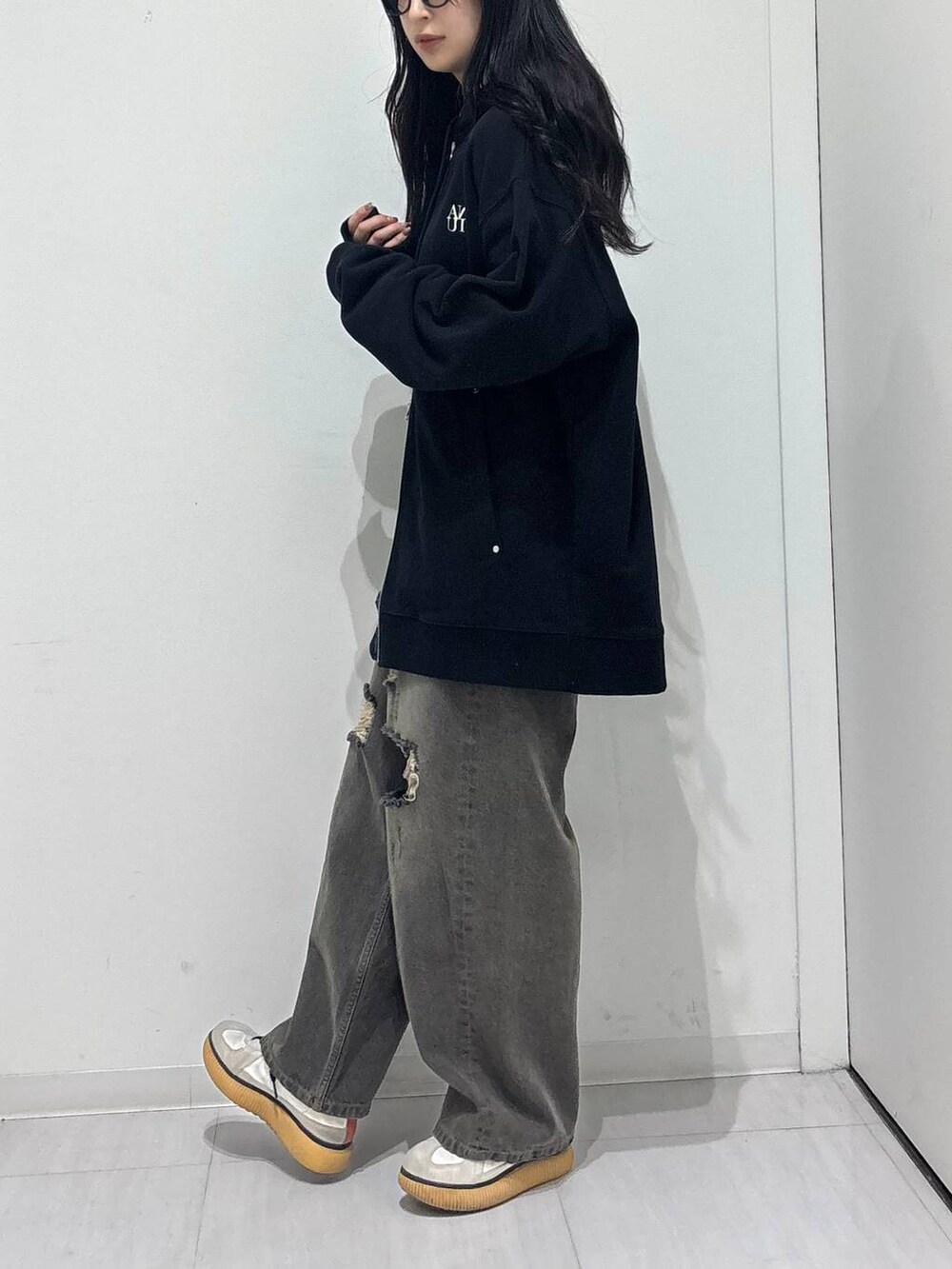 ブラック系のデニムパンツ、ブラック系のパーカーを着用したレディースの秋コーディネートの3枚目の写真