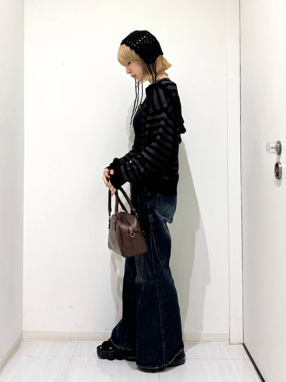 ブラック系のキャミソール、ブラウン系のショルダーバッグ、ブルー系のデニムパンツを着用したレディースの夏コーディネートの3枚目の写真