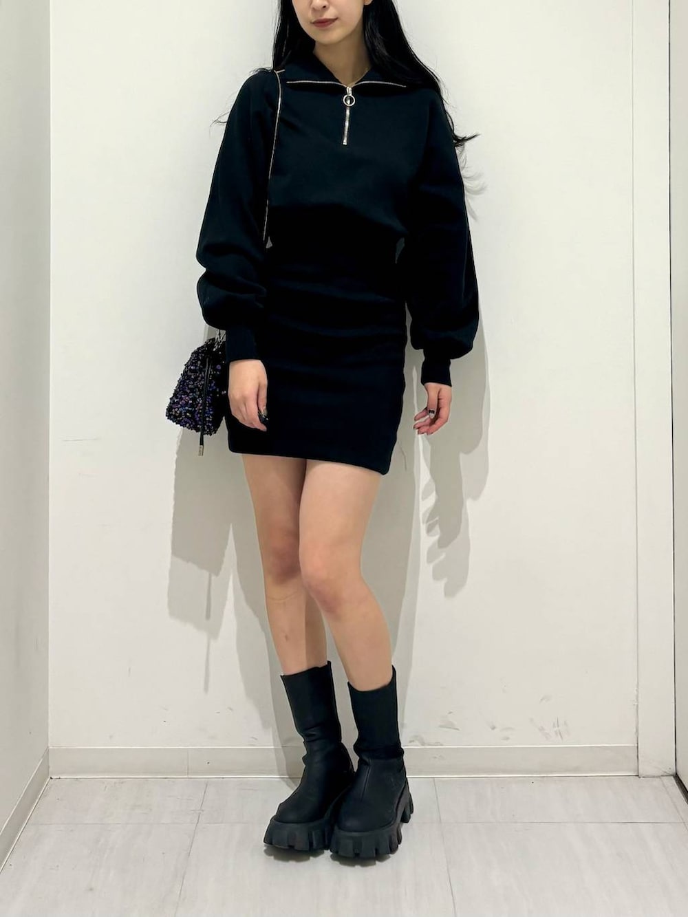 ブラック系のワンピース、ブラック系のブーツ、ブラック系のショルダーバッグを着用したレディースの冬コーディネートの2枚目の写真