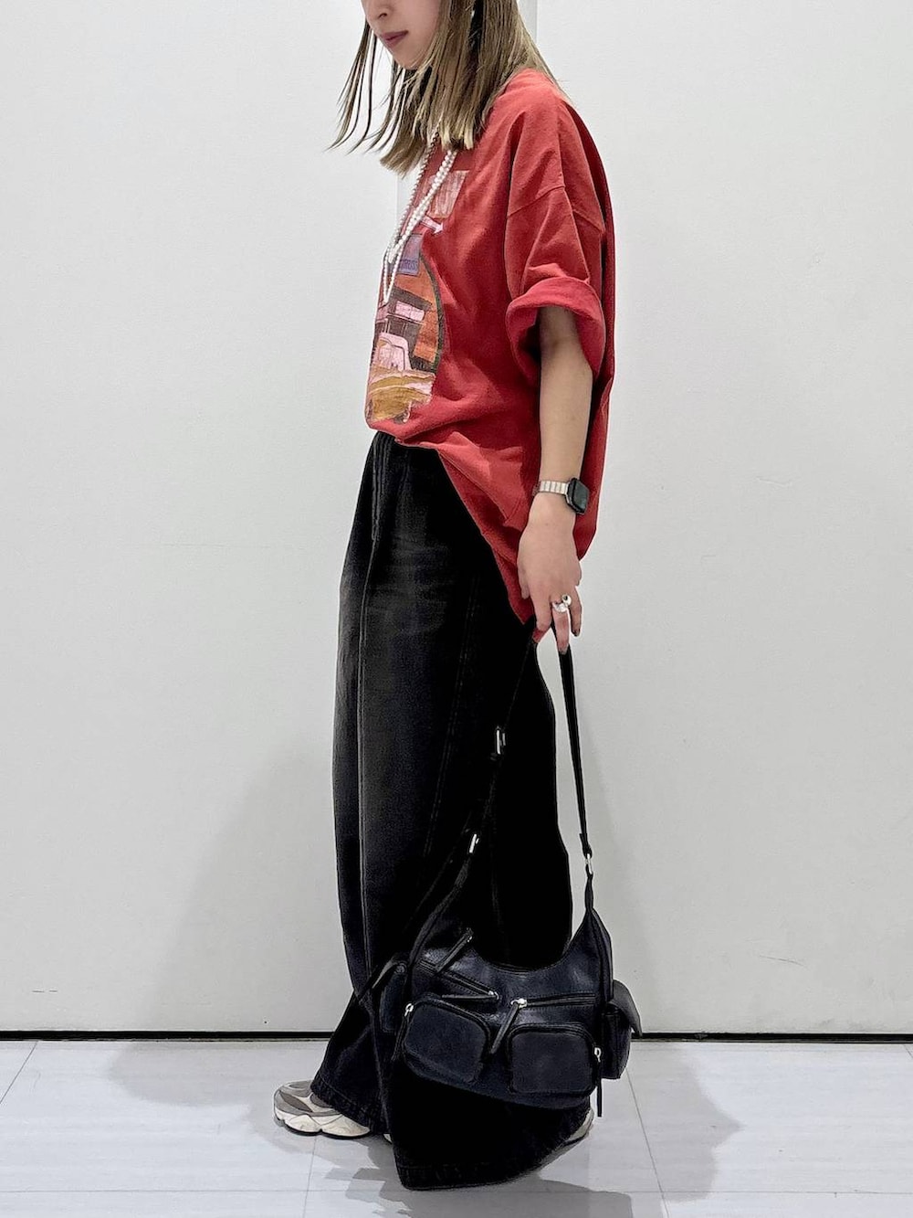 ブルー系のデニムパンツ、ブラック系のショルダーバッグ、レッド系のTシャツ/カットソーを着用したレディースの春コーディネートの4枚目の写真