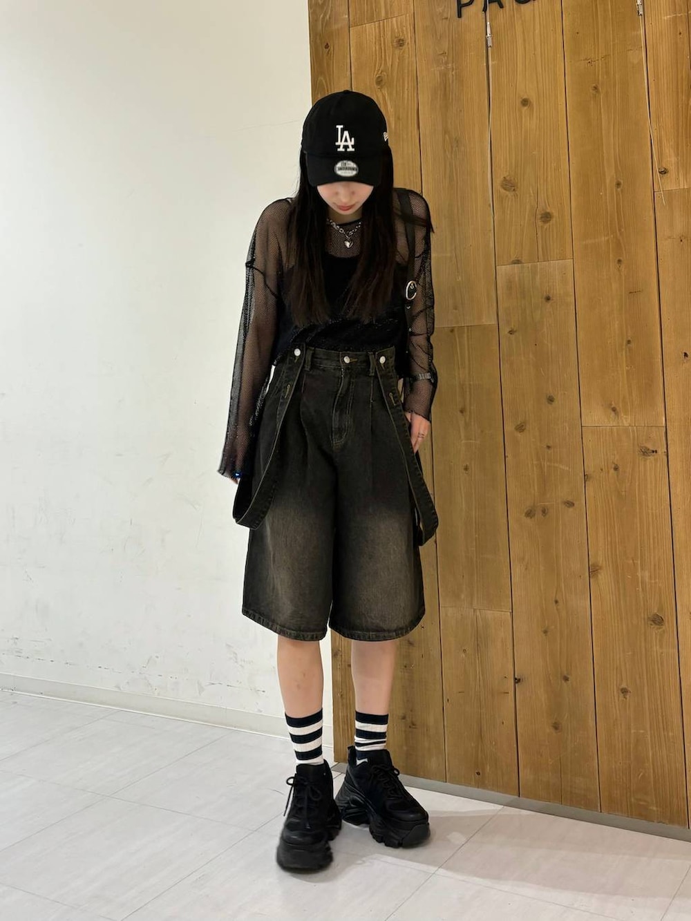 ブラック系のスニーカー、ブラック系のTシャツ/カットソー、ブラック系のデニムパンツを着用したレディースの春コーディネートの5枚目の写真