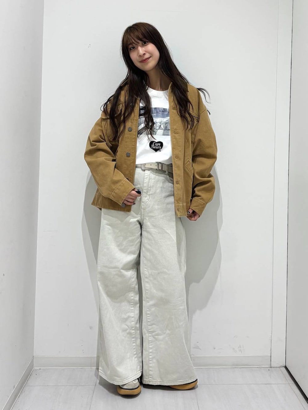 グレー系のデニムパンツ、ベージュ系のカバーオールを着用したレディースの春コーディネートの2枚目の写真