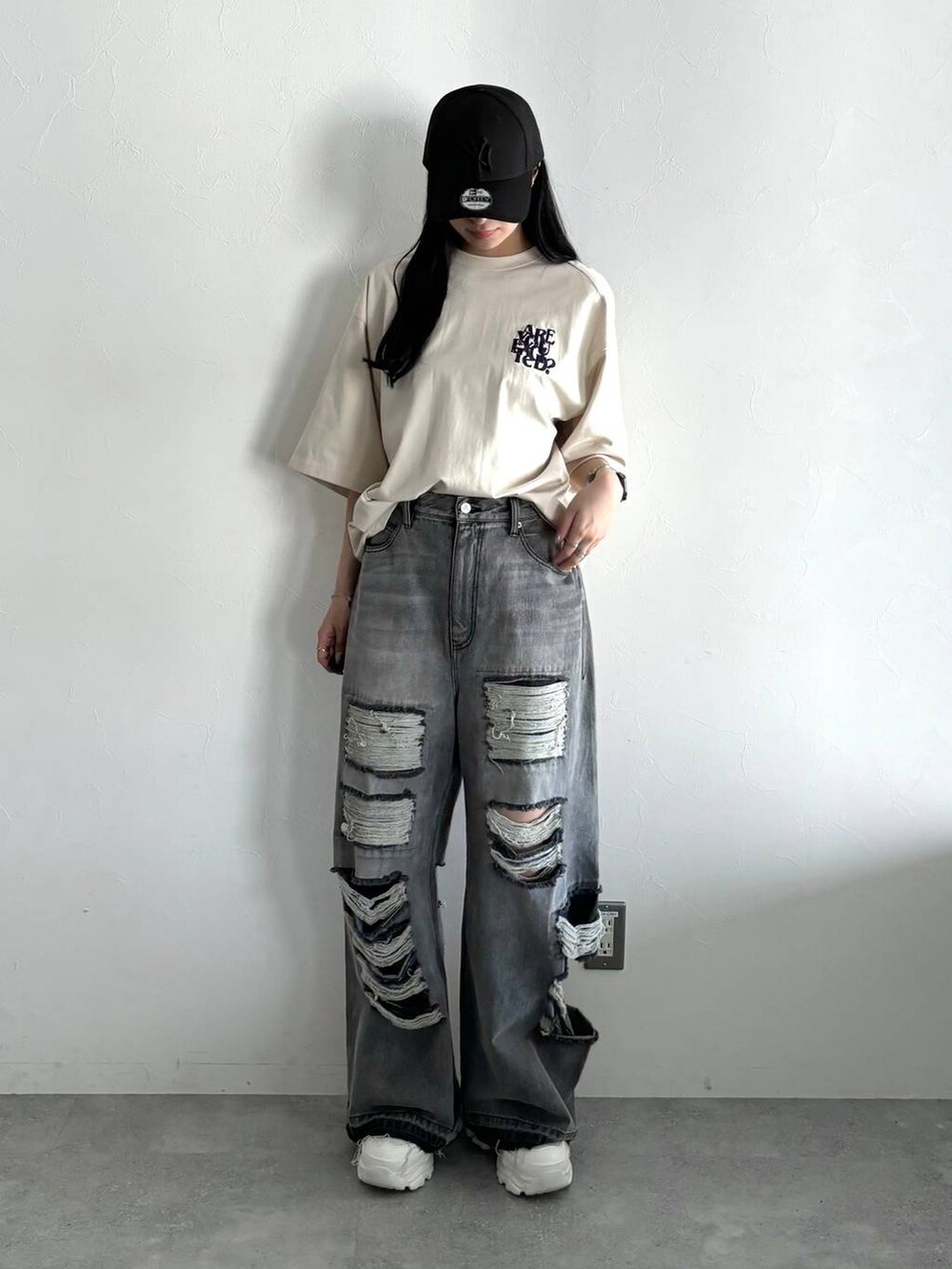 ブラック系のデニムパンツ、ホワイト系のスニーカー、ベージュ系のTシャツ/カットソーを着用したレディースの春コーディネートの4枚目の写真