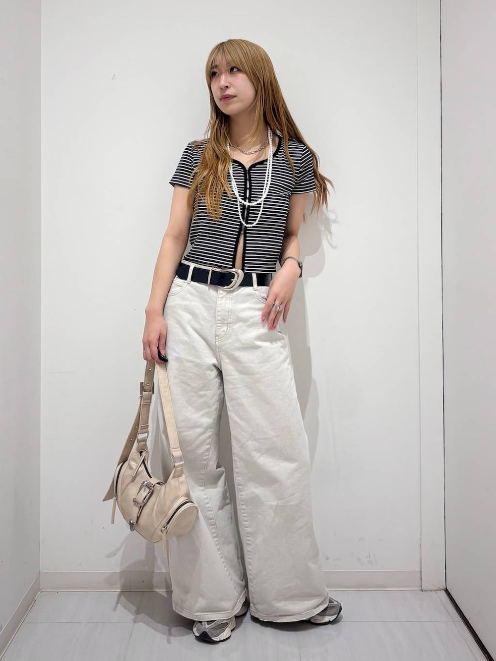 グレー系のデニムパンツ、ホワイト系のショルダーバッグ、ブラック系のTシャツ/カットソーを着用したレディースの春コーディネートの6枚目の写真