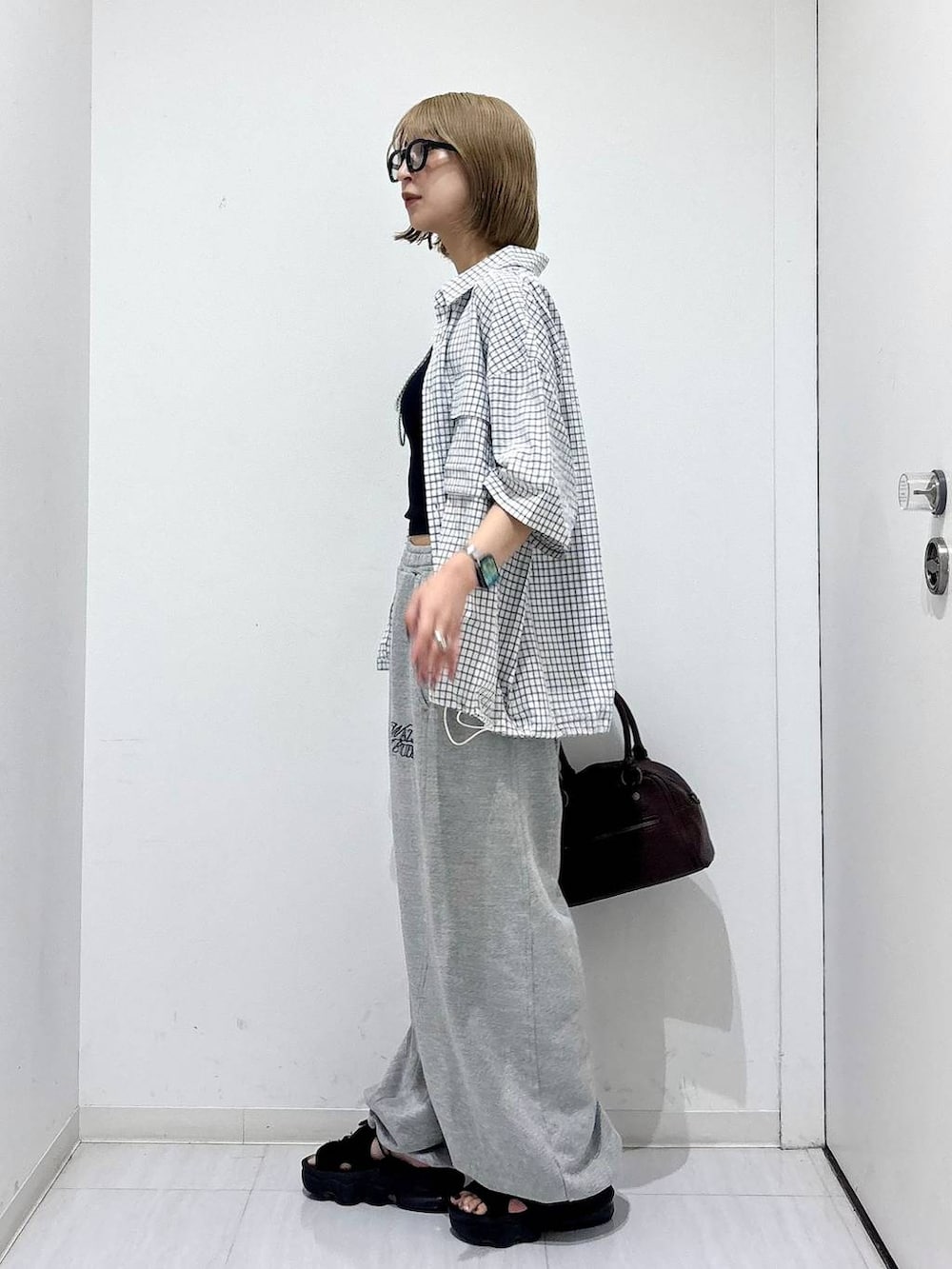 ブラウン系のショルダーバッグ、グレー系のスウェットパンツ、ホワイト系のシャツ/ブラウスを着用したレディースの夏コーディネートの4枚目の写真