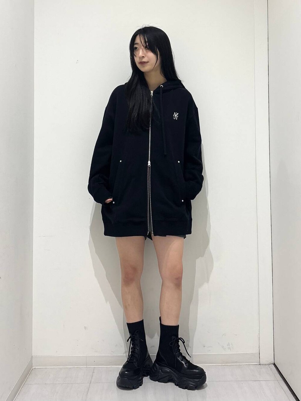 ブラック系のブーツ、ブラック系のパーカー、グレー系のその他パンツを着用したレディースの秋コーディネートの6枚目の写真