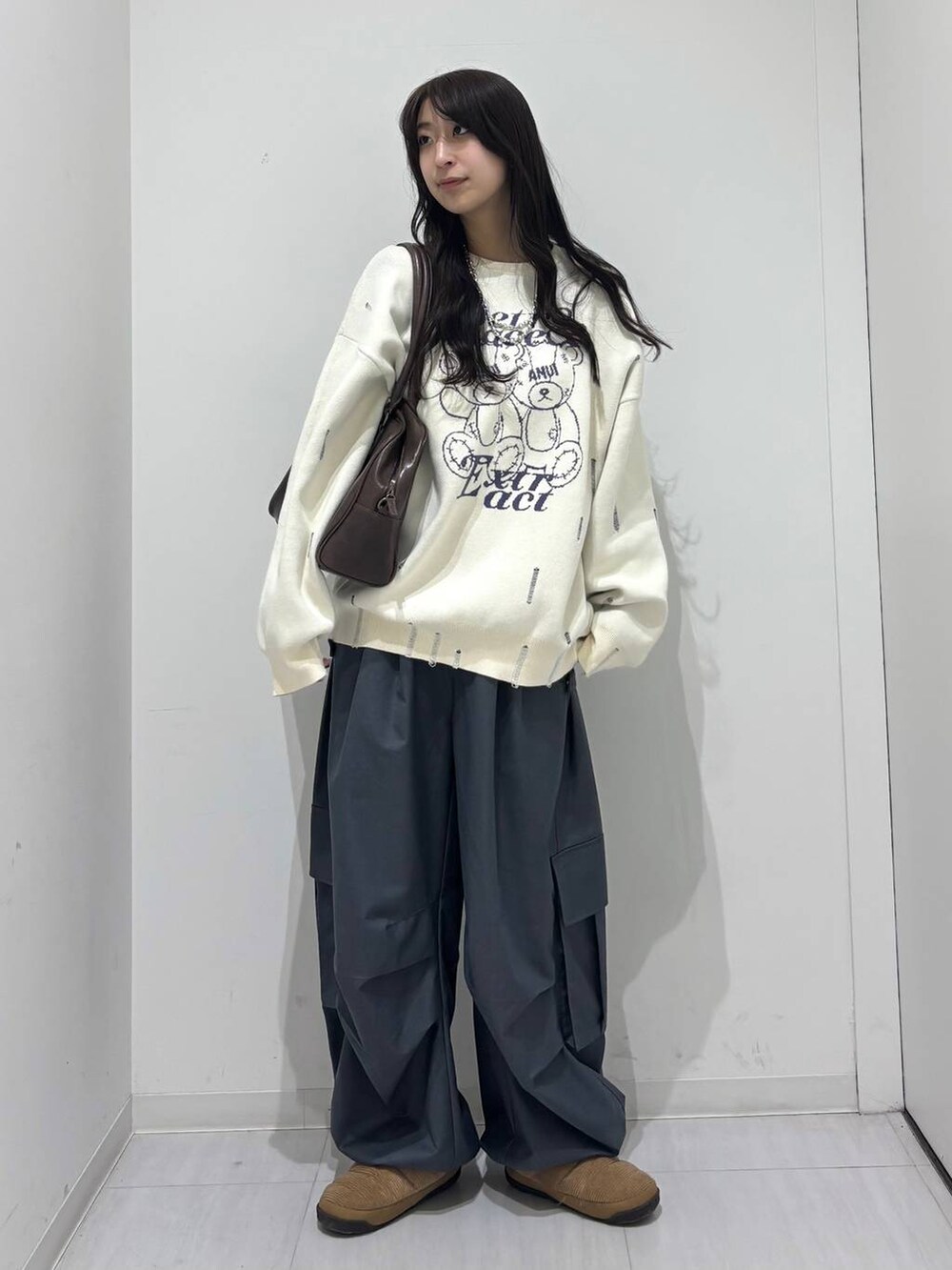 グレー系のカーゴパンツ、ホワイト系のニット/セーター、ブラウン系のボストンバッグを着用したレディースの冬コーディネートの8枚目の写真