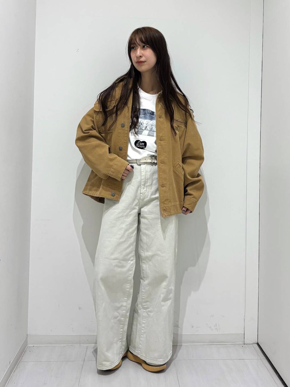 グレー系のデニムパンツ、ベージュ系のカバーオールを着用したレディースの春コーディネートの6枚目の写真