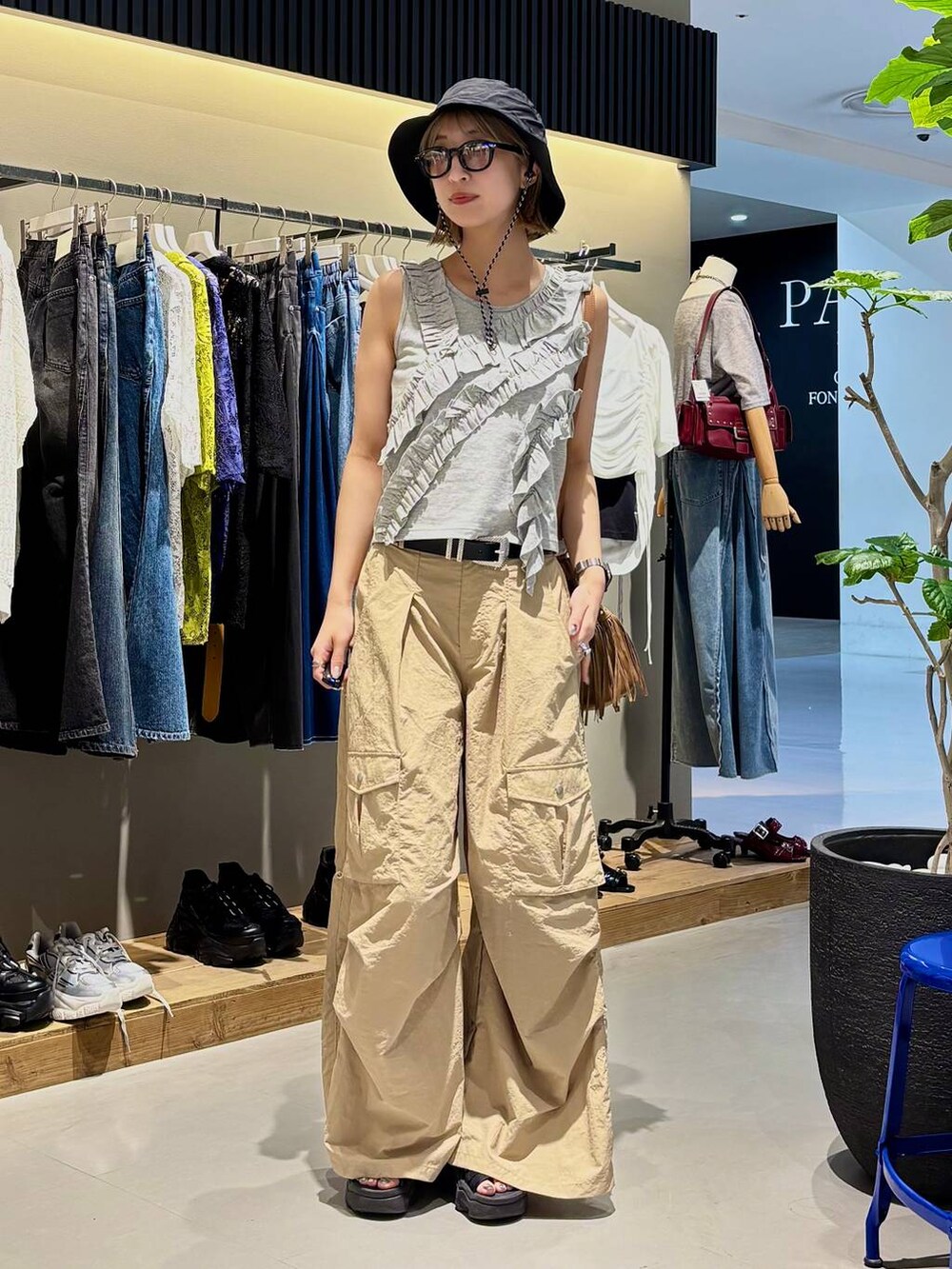 グレー系のタンクトップ、ベージュ系のカーゴパンツ、ブラック系のベルトを着用したレディースの夏コーディネートの7枚目の写真