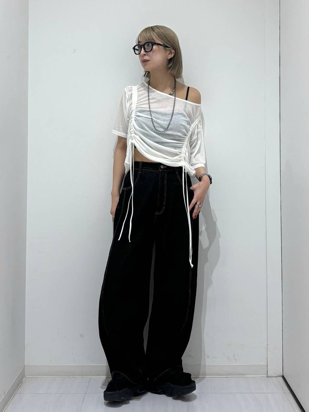 ブラック系のデニムパンツ、ホワイト系のTシャツ/カットソー、ブラック系のネックレスを着用したレディースの夏コーディネートの2枚目の写真