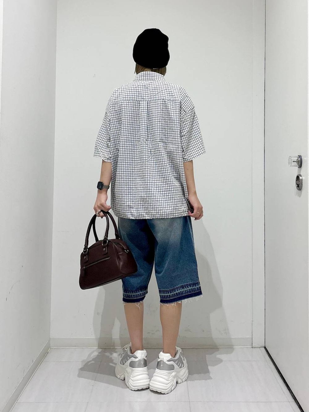 ホワイト系のスニーカー、ブラウン系のショルダーバッグ、ブルー系のデニムパンツを着用したレディースの夏コーディネートの6枚目の写真
