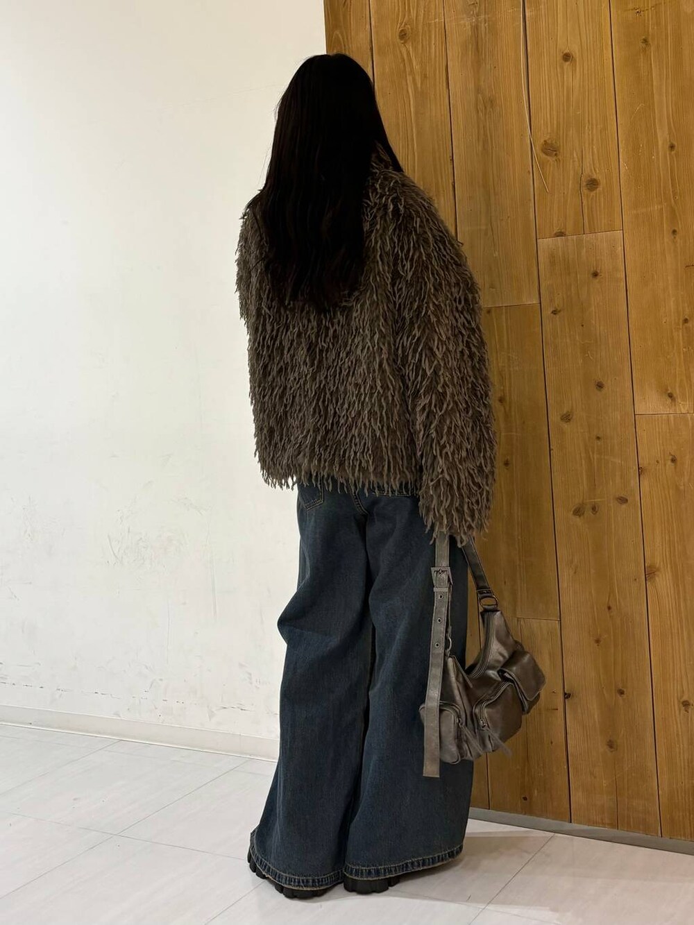 ブルー系のデニムパンツ、その他のショルダーバッグ、ブラウン系のブルゾンを着用したレディースの冬コーディネートの5枚目の写真