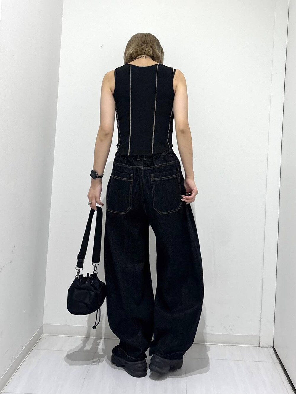 ブラック系のショルダーバッグ、ブラック系のデニムパンツ、ブラック系のタンクトップを着用したレディースの夏コーディネートの5枚目の写真