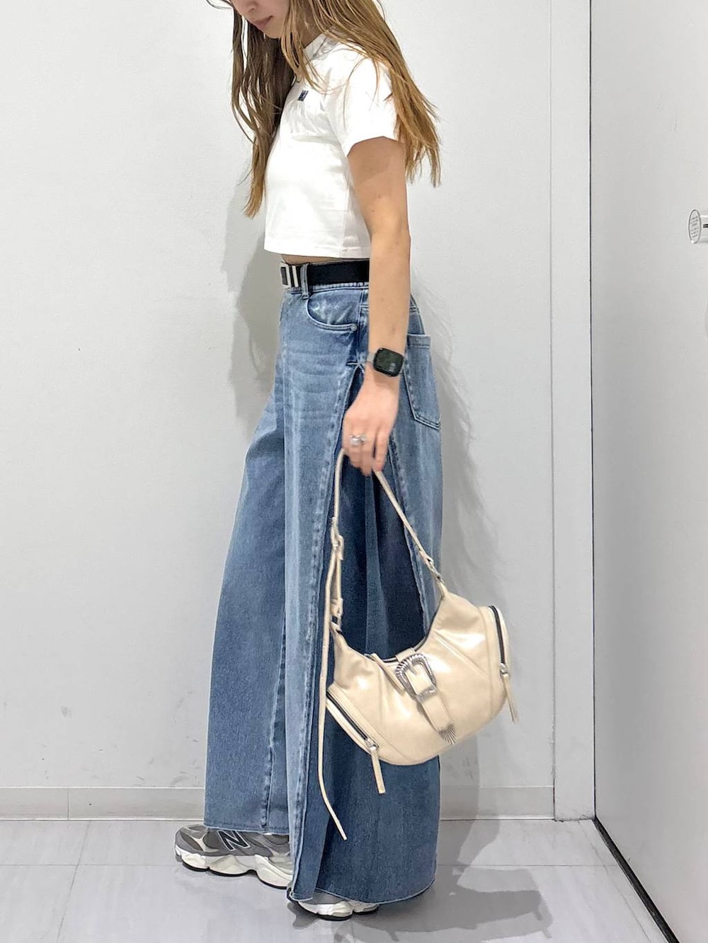 ホワイト系のショルダーバッグ、ブルー系のデニムパンツ、ホワイト系のTシャツ/カットソーを着用したレディースの春コーディネートの3枚目の写真