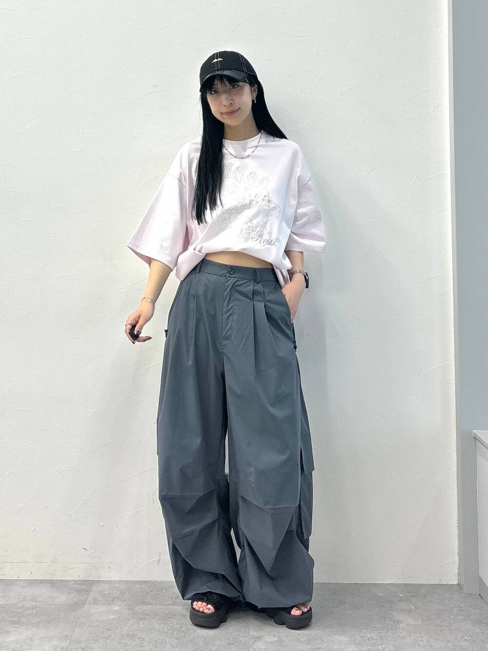 ピンク系のTシャツ/カットソー、グレー系のカーゴパンツ、ブラック系のキャップを着用したレディースの夏コーディネートの2枚目の写真