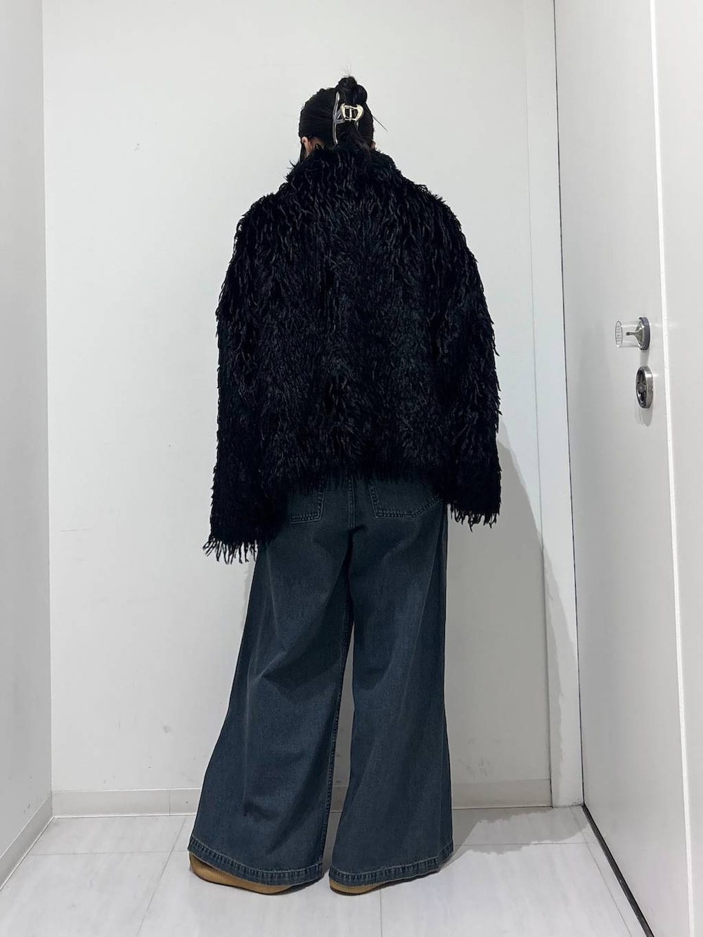 ブルー系のデニムパンツ、ブラック系のブルゾンを着用したレディースの秋コーディネートの4枚目の写真