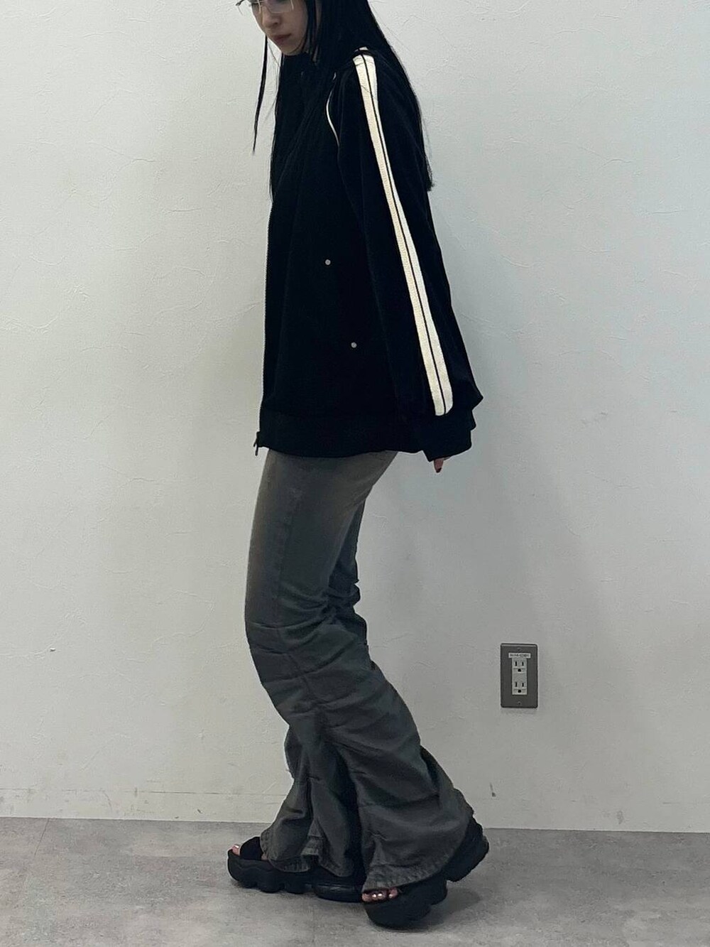 ブルー系のデニムパンツ、ブラック系のジャージを着用したレディースの秋コーディネートの3枚目の写真