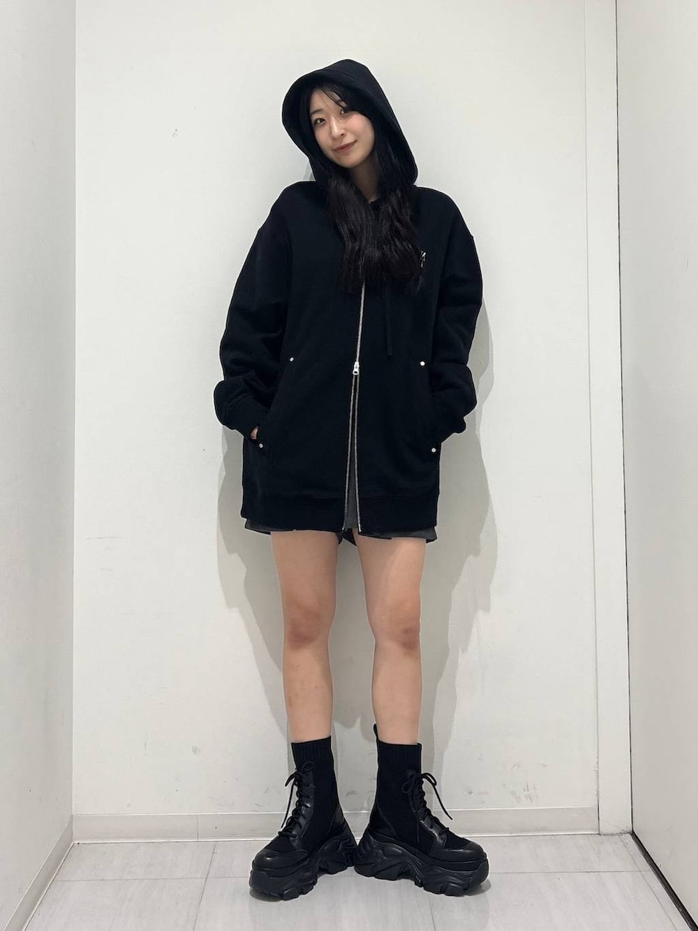 ブラック系のブーツ、ブラック系のパーカー、グレー系のその他パンツを着用したレディースの秋コーディネートの2枚目の写真