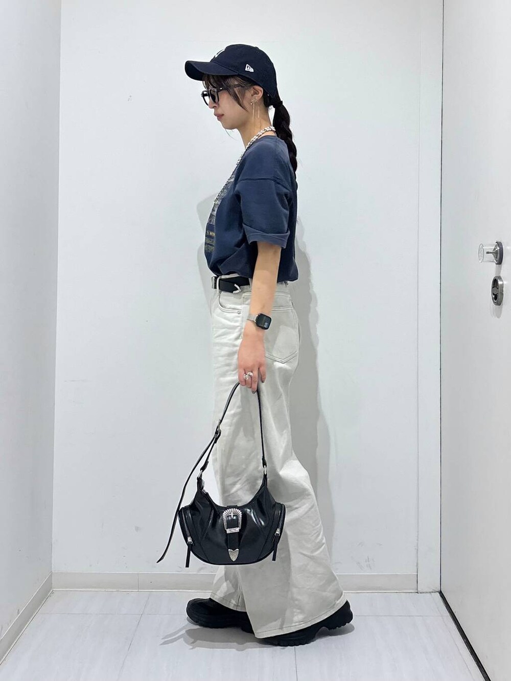 グレー系のデニムパンツ、ブラック系のスニーカー、ブルー系のTシャツ/カットソーを着用したレディースの春コーディネートの3枚目の写真