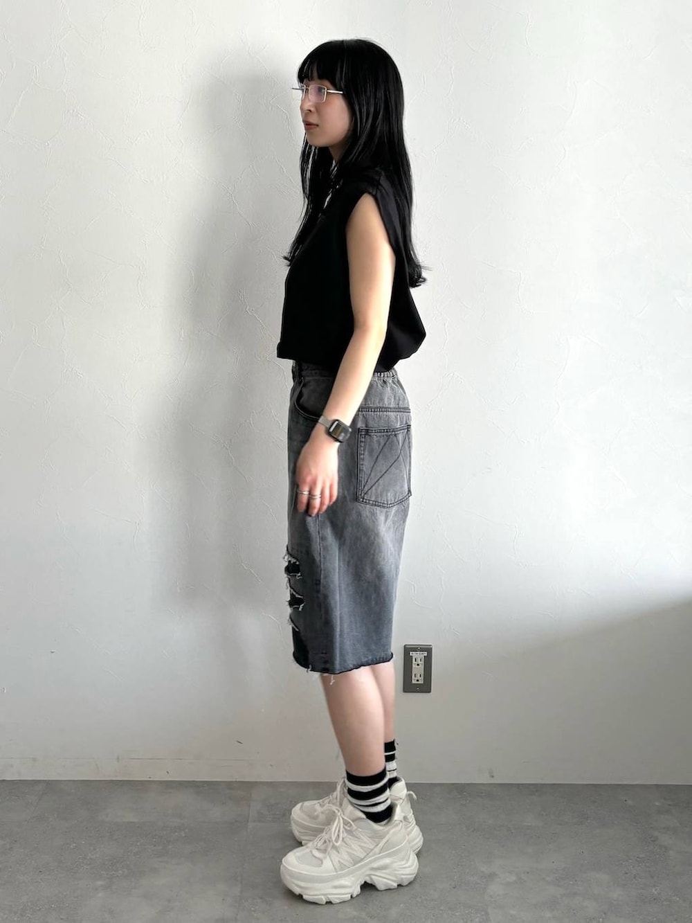 ホワイト系のスニーカー、ブラック系のデニムパンツ、ブラック系のTシャツ/カットソーを着用したレディースの春コーディネートの3枚目の写真