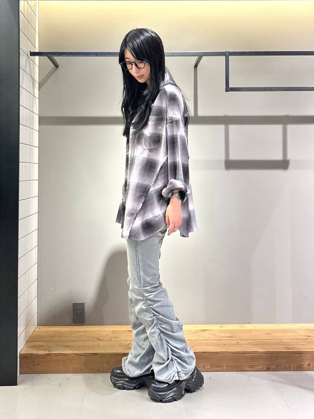 ブラック系のスニーカー、ホワイト系のキャミソール、ブルー系のデニムパンツを着用したレディースの秋コーディネートの3枚目の写真