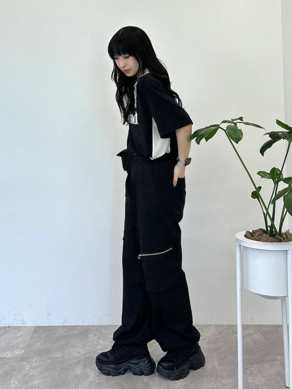 ブラック系のショルダーバッグ、ブラック系のスニーカー、ブラック系のスラックスを着用したレディースの春コーディネートの3枚目の写真