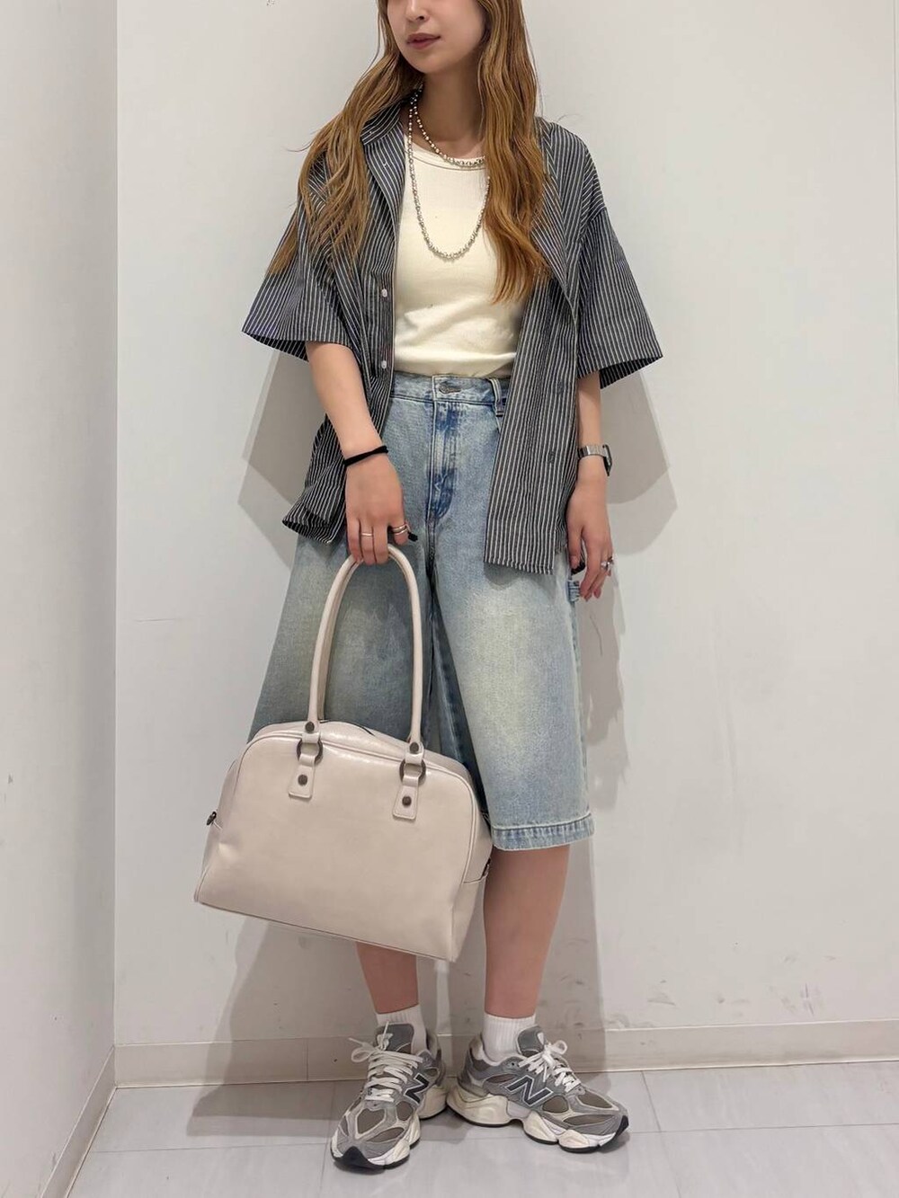 ホワイト系のボストンバッグ、ホワイト系のタンクトップ、ブルー系のその他パンツを着用したレディースの夏コーディネートの3枚目の写真