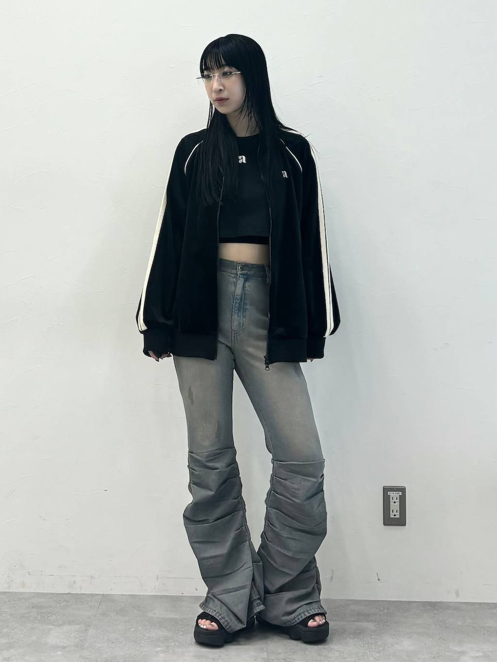 ブルー系のデニムパンツ、ブラック系のジャージを着用したレディースの秋コーディネートの5枚目の写真