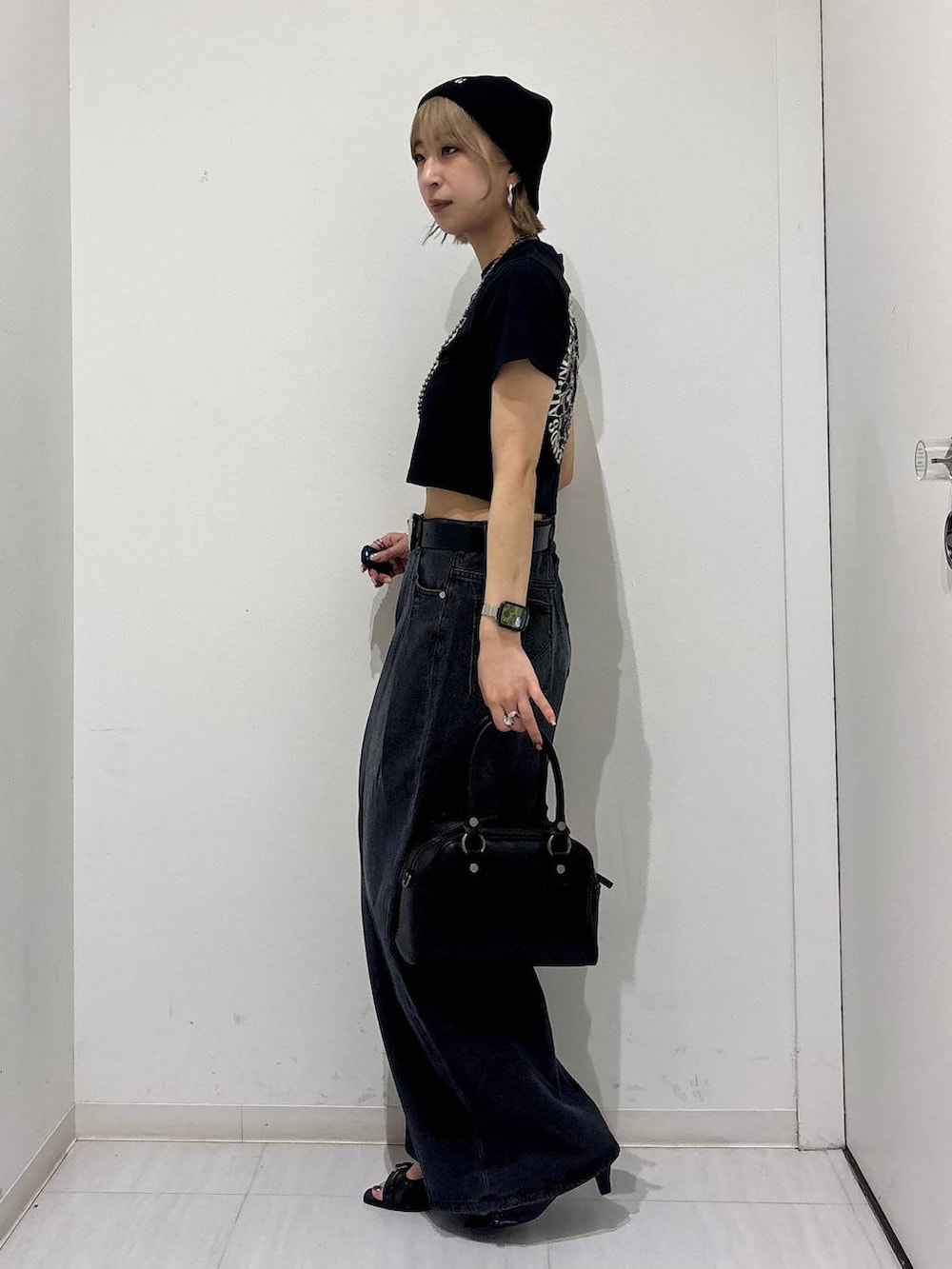 ブラック系のデニムパンツ、ブラック系のサンダル、ブラック系のTシャツ/カットソーを着用したレディースの夏コーディネートの3枚目の写真