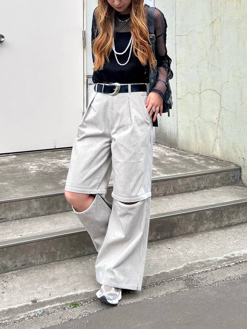 ブラック系のTシャツ/カットソー、ホワイト系のその他パンツ、ブラック系のショルダーバッグを着用したレディースの春コーディネートの2枚目の写真