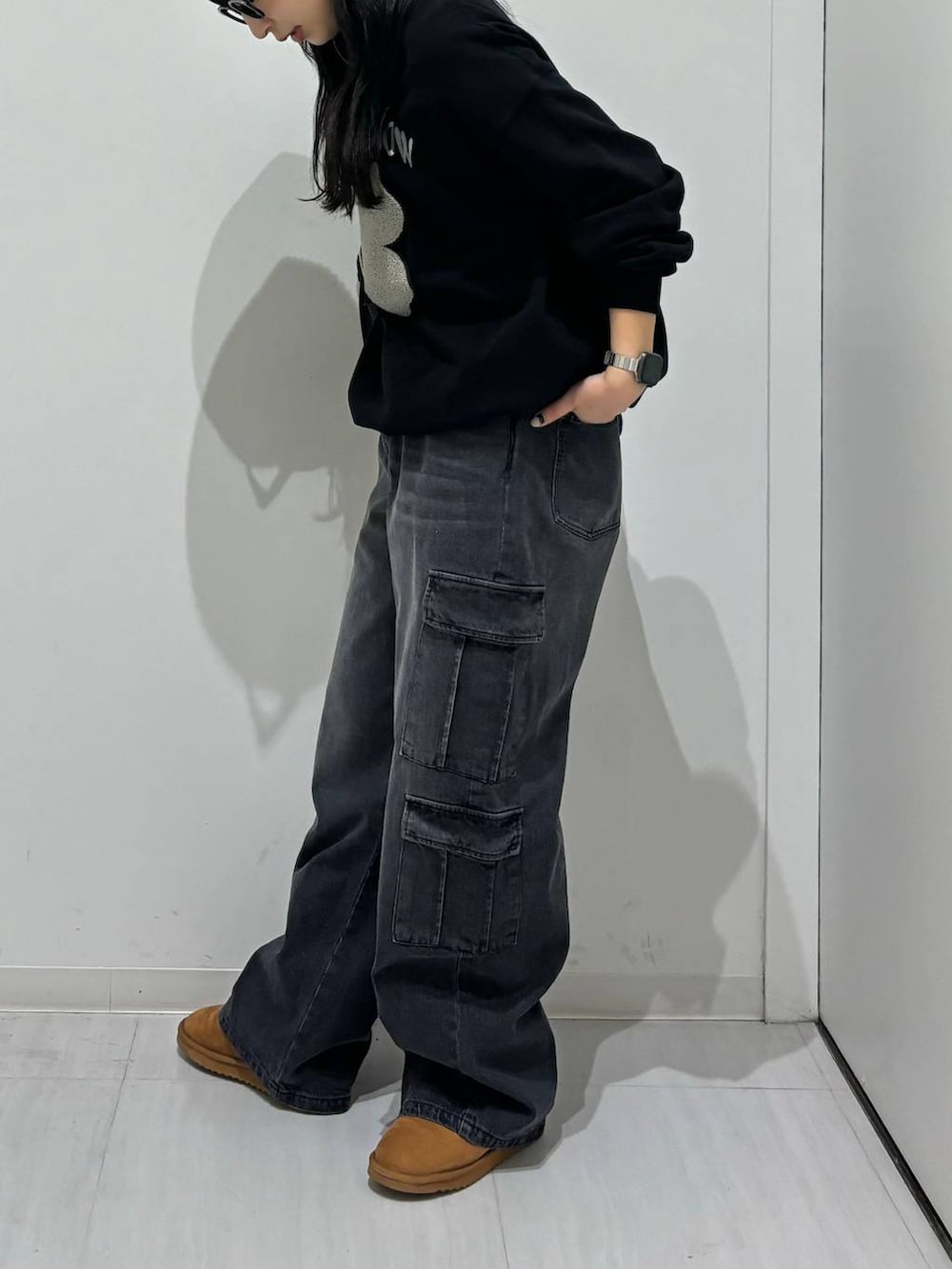 ブラック系のスウェット、ブラック系のショルダーバッグ、ブラック系のデニムパンツを着用したレディースの冬コーディネートの3枚目の写真