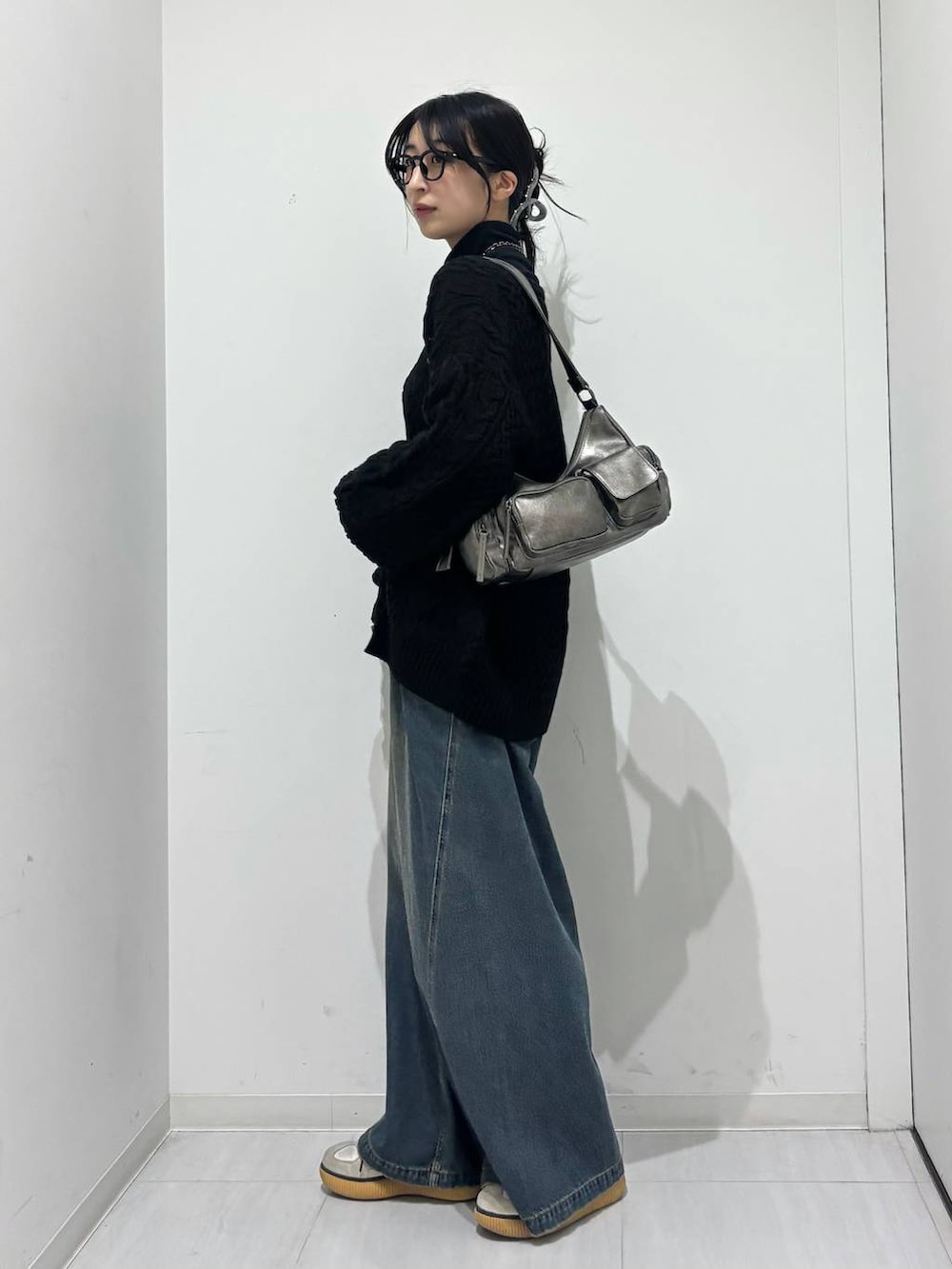 ブルー系のデニムパンツ、その他のショルダーバッグ、ブラック系のTシャツ/カットソーを着用したレディースの秋コーディネートの3枚目の写真