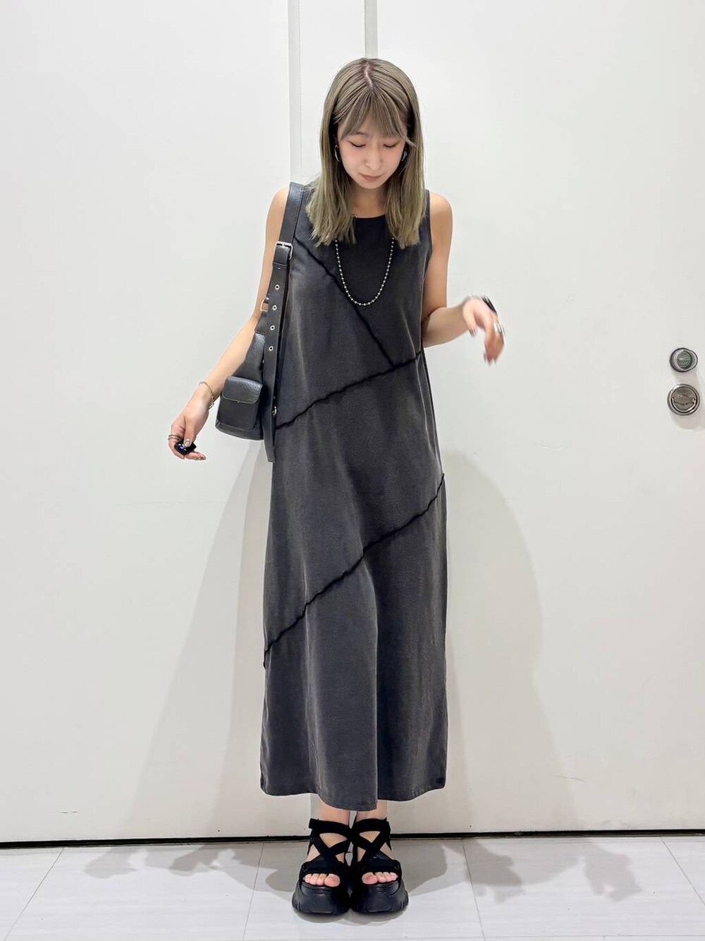 ブラック系のサンダル、ブラック系のワンピース、ブラック系のショルダーバッグを着用したレディースの春コーディネートの4枚目の写真