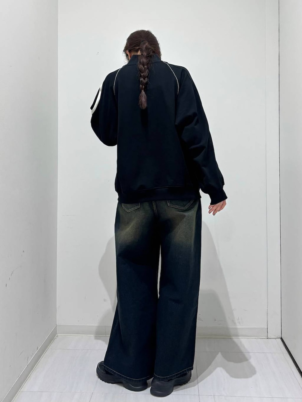 ブルー系のデニムパンツ、ブラック系のスニーカー、ブラック系のスウェットを着用したレディースの春コーディネートの4枚目の写真