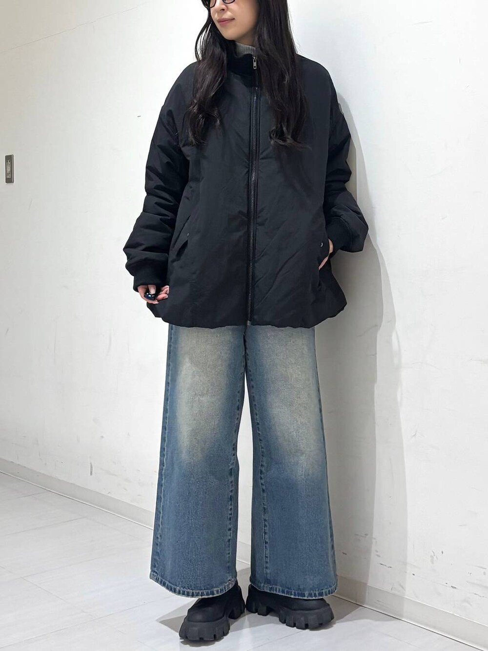 ブラック系のMA-1、ブルー系のデニムパンツを着用したレディースの冬コーディネートの4枚目の写真