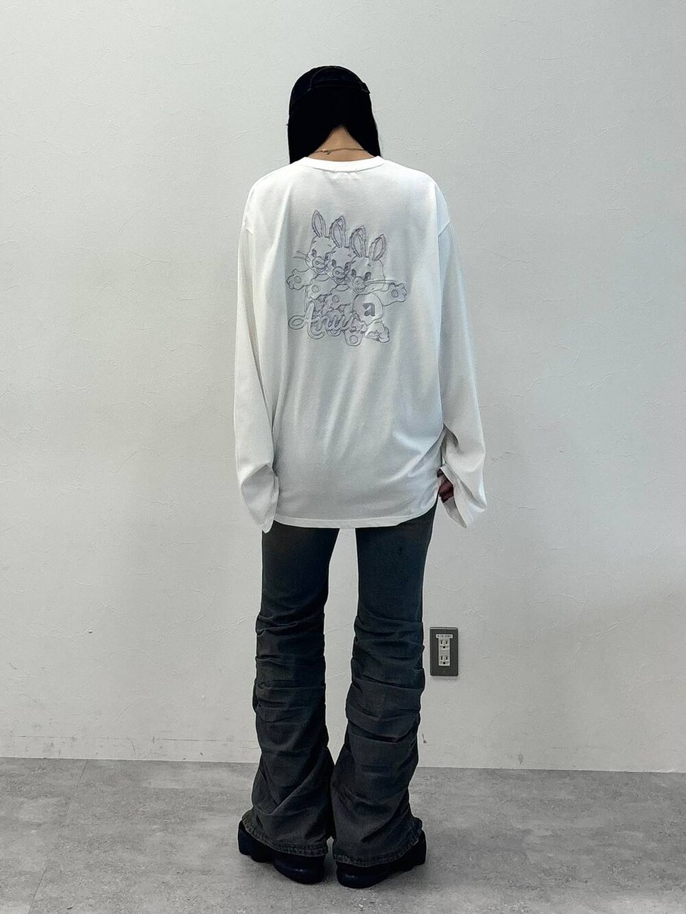 ブルー系のデニムパンツ、ホワイト系のTシャツ/カットソー、ブラック系のキャップを着用したレディースの秋コーディネートの3枚目の写真