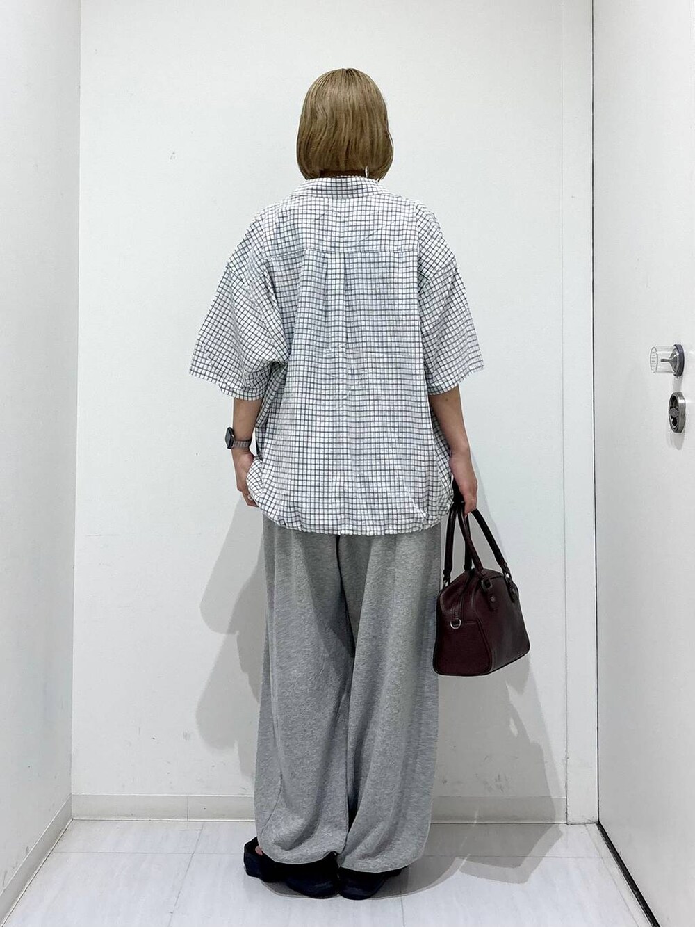 ブラウン系のショルダーバッグ、グレー系のスウェットパンツ、ホワイト系のシャツ/ブラウスを着用したレディースの夏コーディネートの5枚目の写真