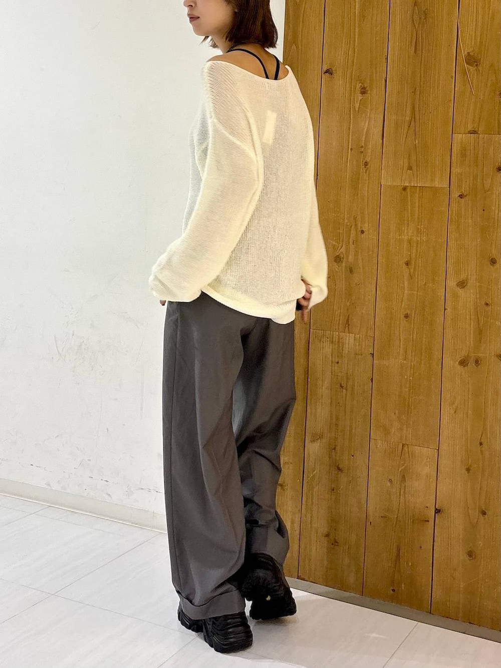 グレー系のスニーカー、ホワイト系のニット/セーター、グレー系のスラックスを着用したレディースの夏コーディネートの5枚目の写真