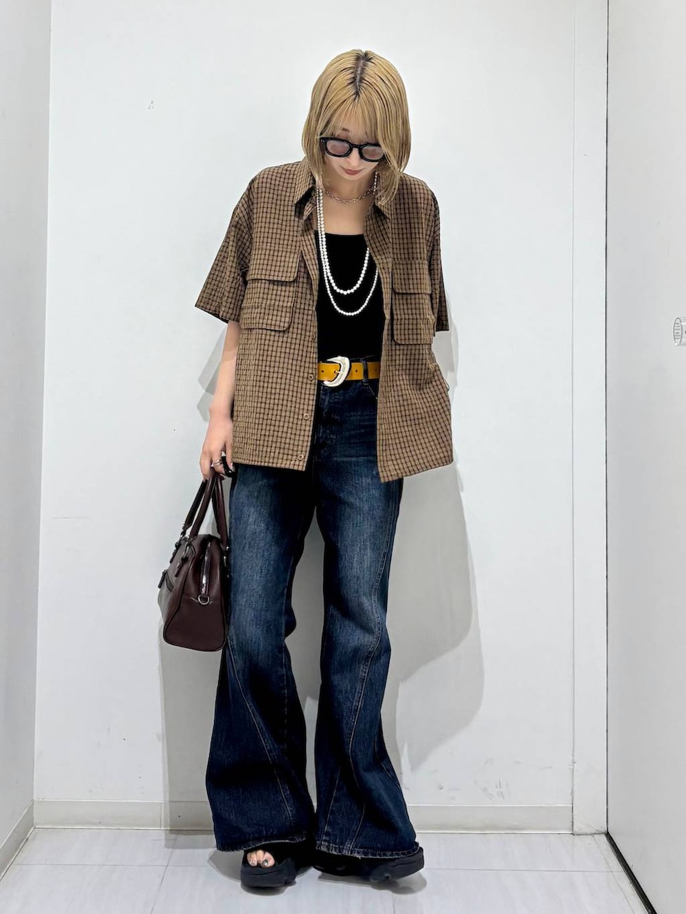 ブラウン系のショルダーバッグ、ブルー系のデニムパンツ、ブラウン系のシャツ/ブラウスを着用したレディースの夏コーディネートの5枚目の写真